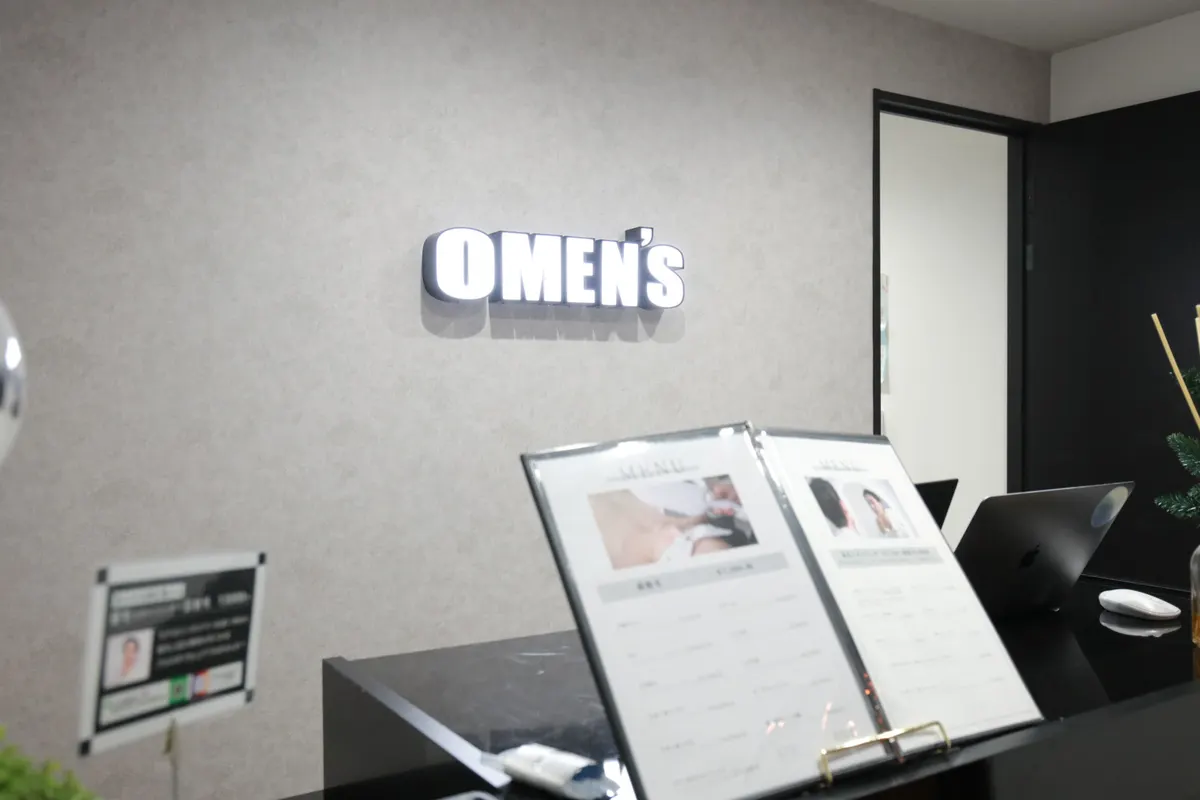 OMEN'S 名古屋高岳本店の受付。壁にOMEN'Sのロゴ